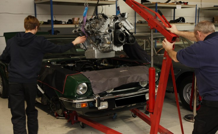 Green Aston Martin v8 Prince of Wales engine being rebuilt.
